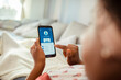 © Davor - Woman checking bank account on smartphone at home