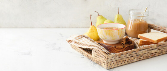 Wall Mural - Tray with tasty pear jam and toasts on light background with space for text