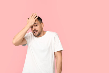 Canvas Print - Handsome worried young man covering face with hand on pink background