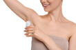© New Africa - Woman applying deodorant on white background, closeup