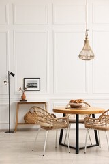Poster - Dining room interior with wooden table and wicker chairs