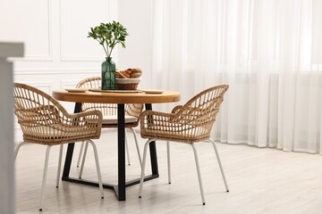 Canvas Print - Dining room interior with comfortable furniture and green branches