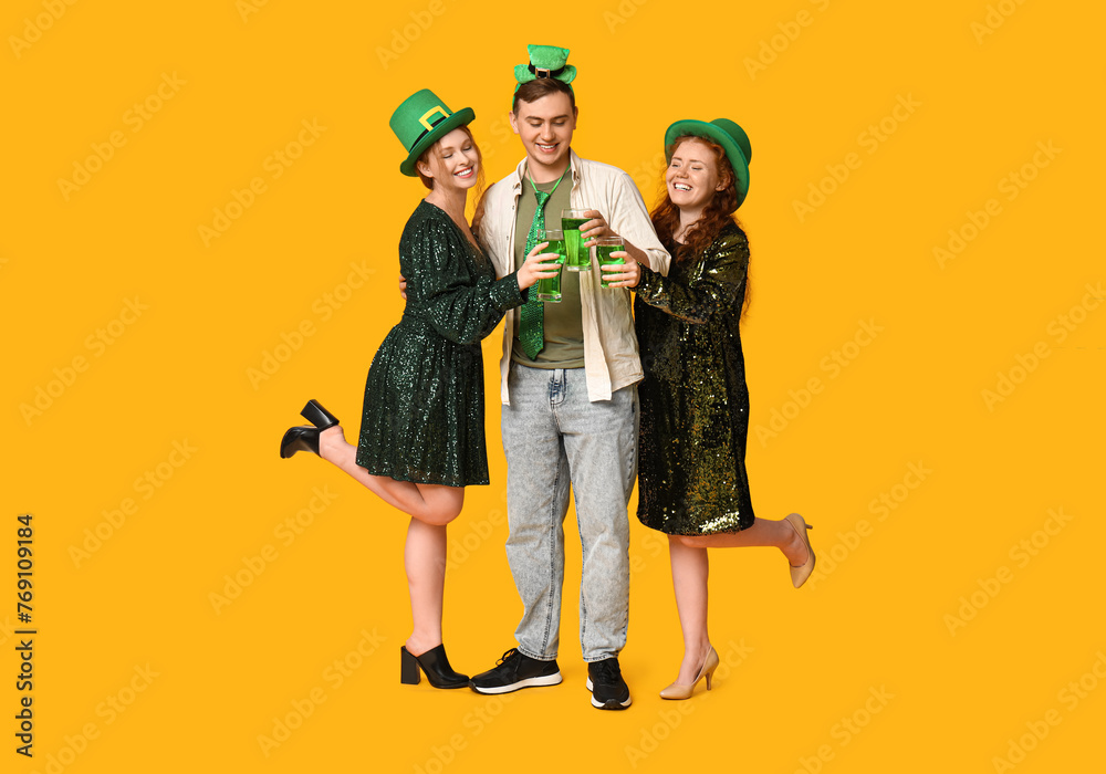 Happy friends with beer on yellow background. St. Patrick's Day celebration