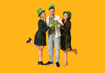 Wall Mural - Happy friends with beer on yellow background. St. Patrick's Day celebration