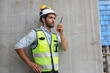 The gesture of a male engineer posing with a walkie-talkie. Strike a pose of a male engineer using a walkie-talkie.