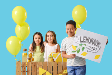 Wall Mural - Cute little children at lemonade stand on blue background