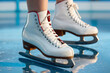 Close-up of white women's skates on a blue clean mirror skating rink. Woman is skating on ice with their skates on