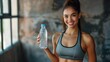 Happy young woman in fitness clothing holding a bottle of water, active woman, banner, copy space
