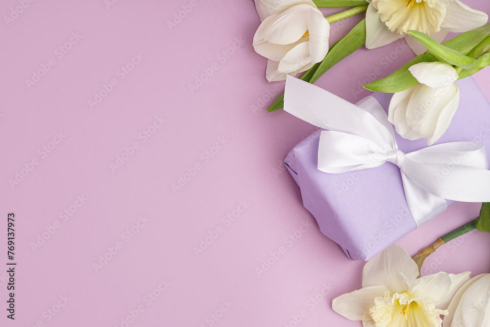 Gift box with beautiful tulips and daffodil flowers on lilac background