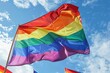 A vibrant rainbow flag is waving in the wind at an outdoor pride parade, surrounded by other colorful flags Generative AI