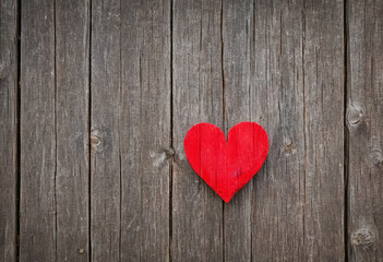 Bright red heart as a symbol of love and friendship on wooden background