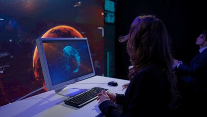 Earth control center, team monitoring galaxy on big screen. Group of people in mission center working on computers, observing discussing flight and space data.