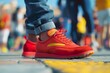 A detailed view of a persons feet wearing vibrant red and yellow sneakers.
