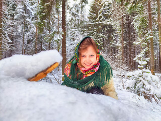 Wall Mural - Cute girl in a traditional Russian headscarf and mittens on winter forest. Closeup portrait of a child in folk clothes. Carnival Maslenitsa