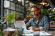 © LifeMedia - Professional man with glasses working on a laptop in a vibrant cafe environment