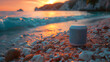 A smart speaker sits on a pebbly beach, capturing the ambiance as the sun sets over the calm sea, casting a warm glow