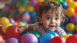 A small child with a joyful expression playing in a colorful ball pit