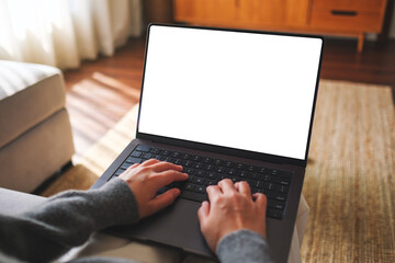 Poster - Mockup image of a woman working and typing on laptop computer with blank white desktop screen at home