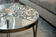  A transitional-style side table with a mirrored mosaic top, reflecting shards of light and adding a touch of glamour to any living space. 
