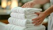 Hand professional chambermaid putting stack of fresh towels in hotel room