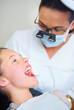 Dentist, consultation and woman with girl, kid and checkup for teeth whitening and oral healthcare. Professional, child and patient with medical procedure and appointment with dental hygiene or trust
