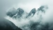 Ethereal Mountains Shrouded in Mist Ethereal and jagged mountain peaks emerge from a dense, misty veil, offering a sense of mystery and the sublime in nature.