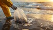 A person wearing gloves is picking up plastic bags that pollute the beach, contributing to environmental conservation efforts