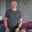 © peopleimages.com - Physiotherapist, man and portrait on bed smiling for training, health care and wellness. Fitness, athlete or physical therapist ready for consultation professional, happy and prepared for appointment