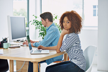Poster - Portrait, African woman and coworking on laptop at desk in an office, internet and work project. Diverse people, workstation and technology screen in workplace with online, business and partnership