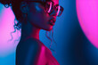 Fashion Surreal Concept. Stunning tousled hair girl of neon glow lighting, shimmer makeup wearing glasses spectacle. illuminated with dynamic composition and dramatic lighting. copy text space