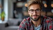 © Pixel Mind - A man wearing glasses sits at a wooden table