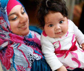 Wall Mural - Happy, portrait and muslim mom with baby in home with love and care for family in Saudi Arabia. Infant, child and Arabic mother relax in house with support and kindness for kid in embrace of mama