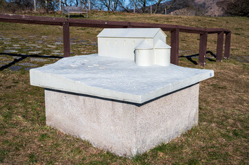 Statue of model of white historic house. In park with lawn. Sunny weather.