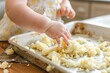 toddler playing with leftover mashed potatoes on tray