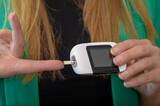 Fototapeta Pomosty - Kobieta sprawdza poziom glukozy we krwi 