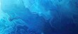 A close up of an electric blue background with a fluid marble texture, resembling underwater azure waters. Perfect for recreation and marine biology enthusiasts