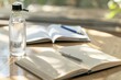 water in ecofriendly reusable bottle, with pen and open notebook on table
