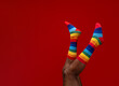 © VISTA by Westend61 - Legs of man wearing colorful socks against red background