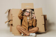 © VISTA by Westend61 - Smiling businesswoman sitting in carton box against white background