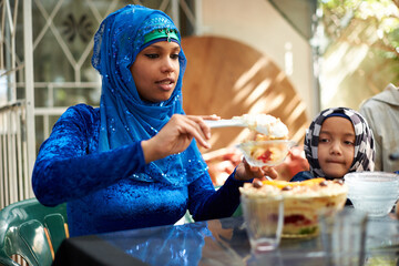 Wall Mural - Family, muslim and table with dessert for ramadan or eid for religious holiday, celebration and eating at home. Islam, traditional and people with hijab for festival, culture and food for fasting