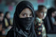 Portrait d'une belle jeune fille naturelle de religion islamiste vétue de noir avec un voile dans une salle de classe
