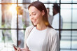 © Katsiaryna - Businesswoman with phone in modern office