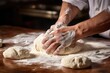 Zoomed-in shot of a baker's hands shaping dough into rolls.
