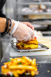 © pavel siamionov - A skilled chef’s hands meticulously assemble a gourmet burger, layering ingredients for optimal taste. Fries await plating