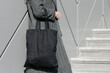 Black tote bag or eco cotton bag in woman's hand