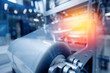 © Parilov - Operation of automatic machine plastic form for kit medical production. Closeup of roller blue toning, with sun lighting effect