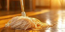 A Mop Is Laying On The Floor Next To A Ball Of Yarn