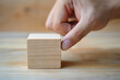 photo of a person pressing on a blank wooden block