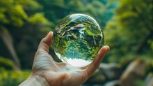 Person's Hand Gently Holds A Crystal Clear Glass Sphere,which Reflects The Vibrant Green Landscape In The Background This Image Represents The Concept Of Clarity,vision,and Environmental