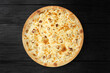 Cheese pizza top view on black wooden background